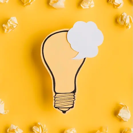 Illustration d'une ampoule en papier avec une bulle de pensée sur fond jaune, symbolisant les idées et astuces pour le bien-être au travail